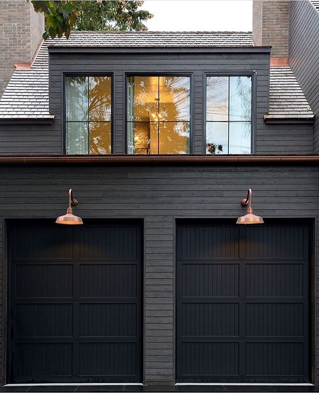 The Black Painted House with Horizontal Wood Piece Over Garage Doors: A Unique Architectural Style